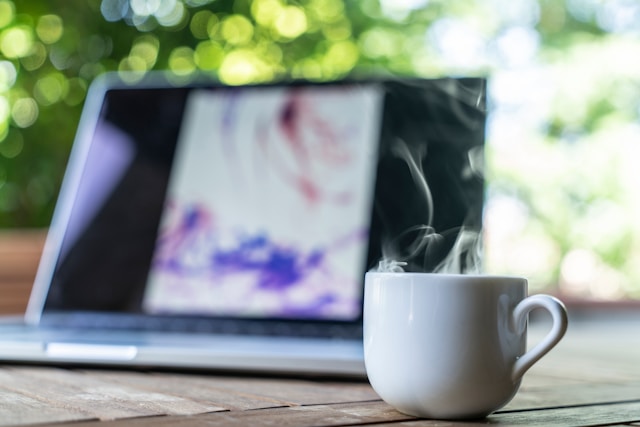 Ordinateur posé sur une table avec un café